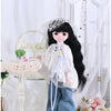 A princess doll dressed in a white outfit and veil, standing next to accessories and flowers.