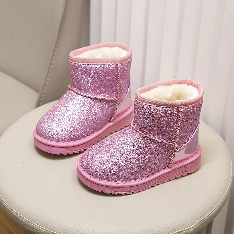 A pair of sparkly pink winter snow boots with faux fur lining resting on a white surface.