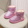 A pair of sparkly pink winter snow boots with faux fur lining resting on a white surface.