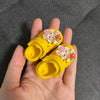 Yellow fashion slippers adorned with pink and white floral decorations for doll accessories