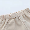 Close-up of a beige pleated fabric detail from a toddler's polo set.