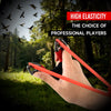 A hand holds a red rubber slingshot, demonstrating high elasticity for professional players in an outdoor setting.
