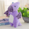 A purple soft triceratops plush dinosaur toy sitting on a table next to books and green plants.