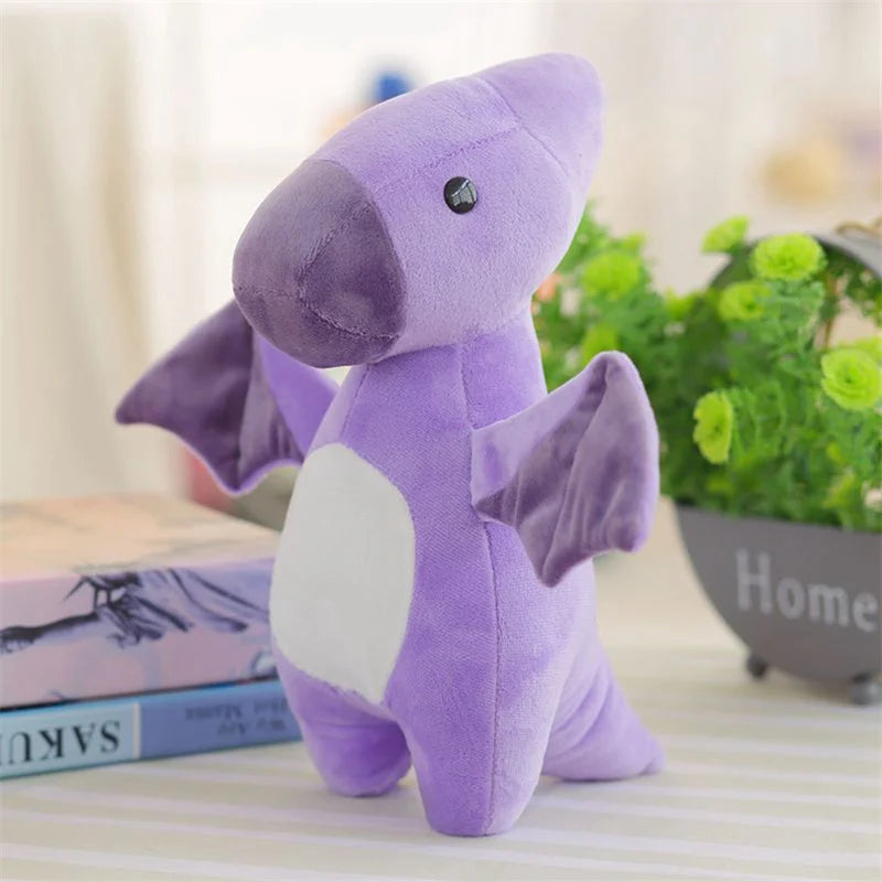 A purple soft triceratops plush dinosaur toy sitting on a table next to books and green plants.