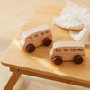 A wooden Montessori push cart toy featuring a handcrafted beech car and bus set resting on a light wooden table.