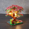 A miniature sakura tree built from wooden blocks with pink flowers and glowing lights.