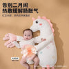 A white unicorn plush toy with pink accents is shown next to a baby, demonstrating a warm massage technique.
