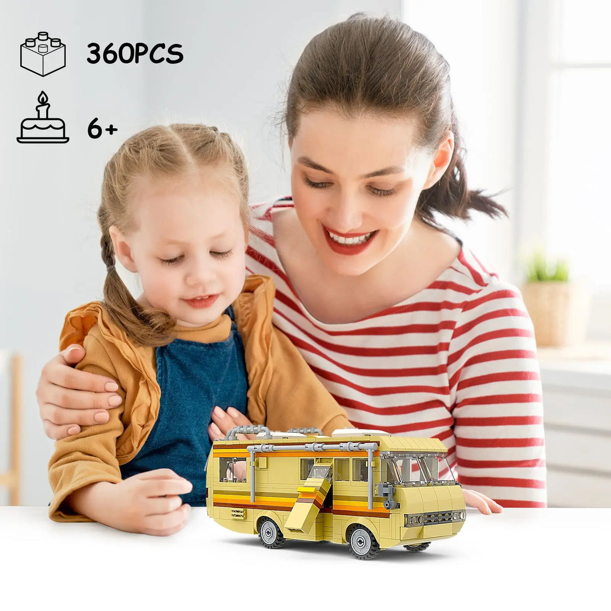 A smiling woman is holding a child and a yellow RV building blocks set with 360 pieces.
