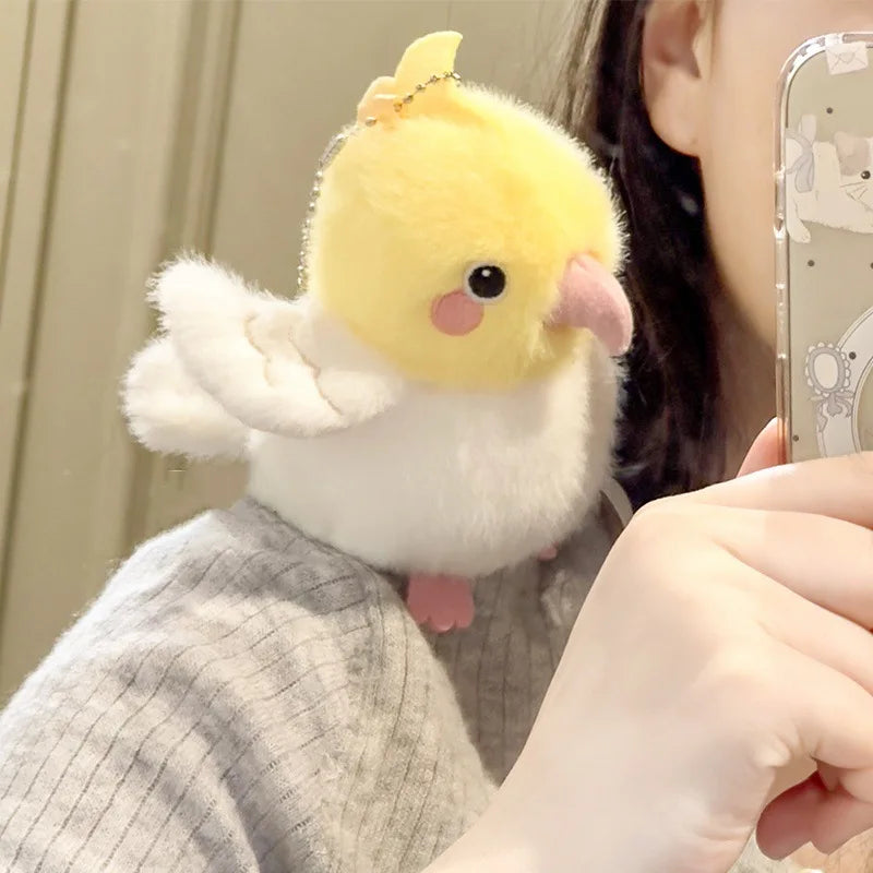 A yellow and white cartoon bird plush toy being held by a person's hand.