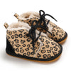 A pair of leopard print soft sole baby sneakers with fuzzy lining and black laces.