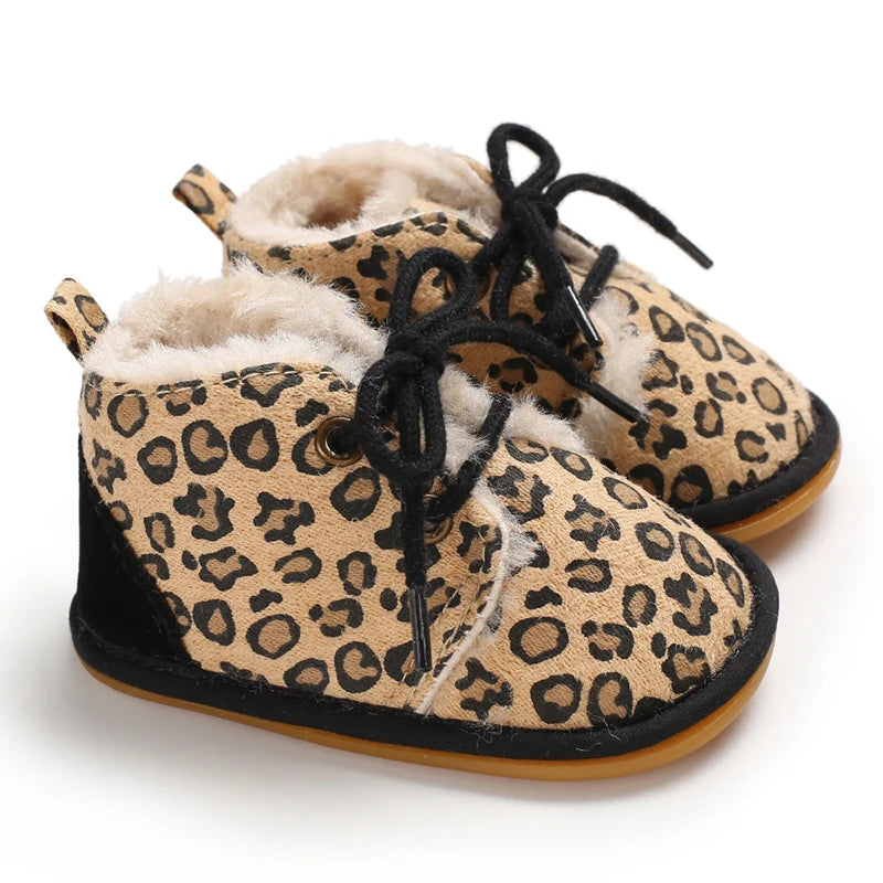 A pair of leopard print soft sole baby sneakers with fuzzy lining and black laces.