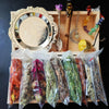 A witchcraft starter kit displayed in a wooden box featuring crystals, herbs, and a decorative mirror.
