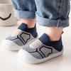 A pair of navy and beige breathable anti-slip baby first walker shoes worn by a child.