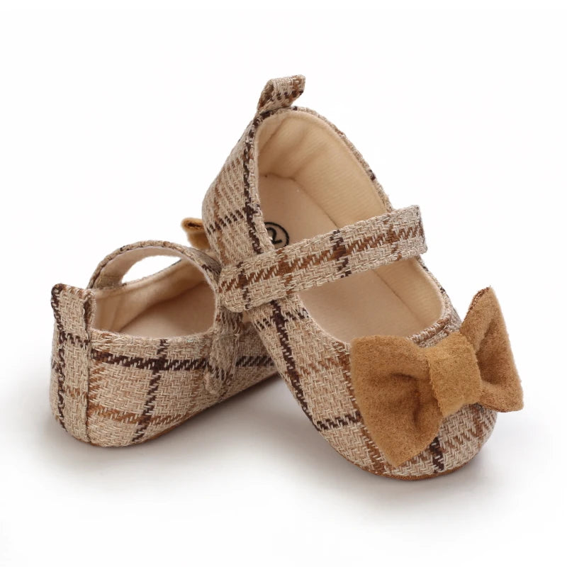 Pair of tan plaid baby walking shoes with suede bow detail