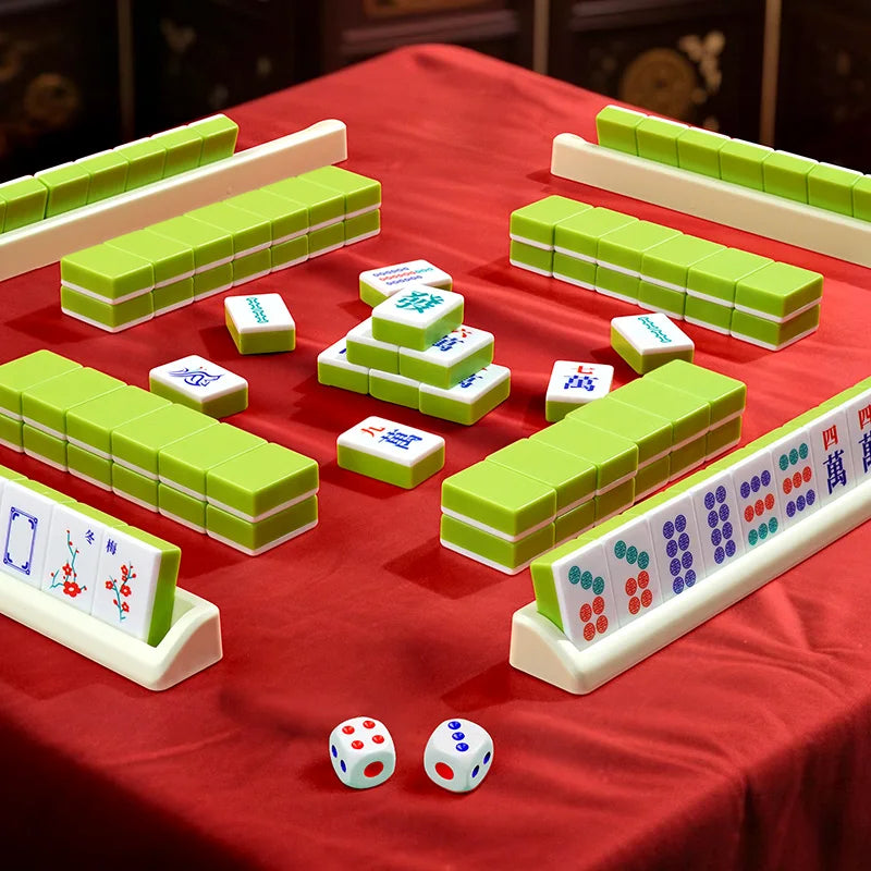 A red cloth displays a complete 144-tile Mahjong set with carrying case, featuring green tiles and white tiles.