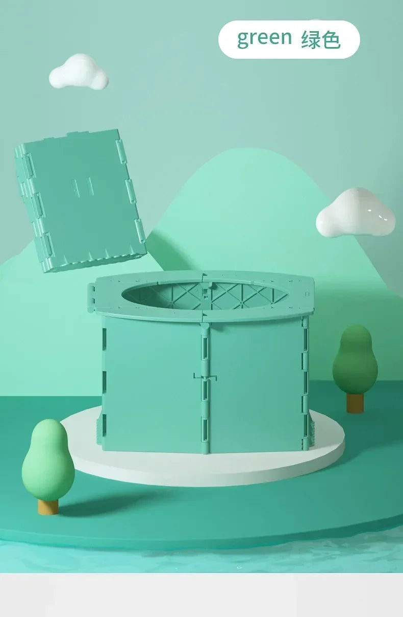 A green foldable baby potty training seat is displayed on a white stand against a light green background.