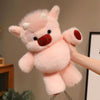 A pink plush toy resembling a West Highland calf or cow doll with white horns and a red nose is being held by a hand.