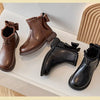 A collection of brown and black girls' ankle boots featuring bow-knot details and side zippers displayed on a white surface.
