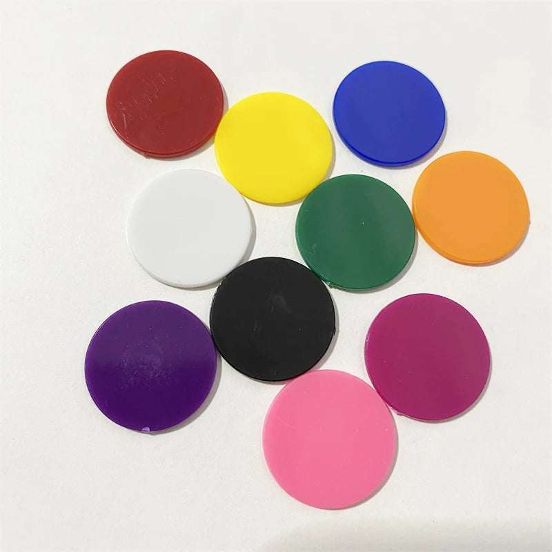 A collection of colorful plastic game markers in various solid colors including red, yellow, blue, green, orange, purple, and