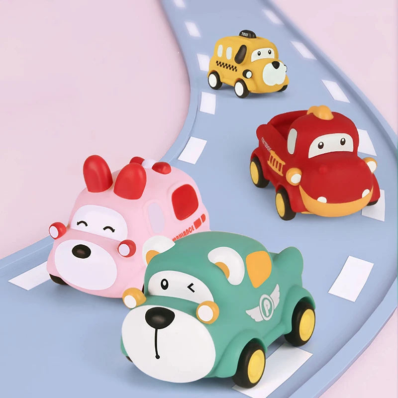 A set of soft rubber pull-back toy cars in yellow, red, and green colors on a light blue surface.