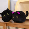 A pair of black kawaii cat plush toys with purple ears sitting on a wooden surface.