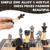 A hand holds a wooden chess piece, with various acrylic and metal chess pieces displayed on a wooden board.
