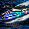 A sleek, blue high-speed RC boat with bright LED lights cutting through dark water.