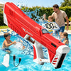 A red electric automatic water gun is spraying water in a swimming pool, with a man and child nearby.