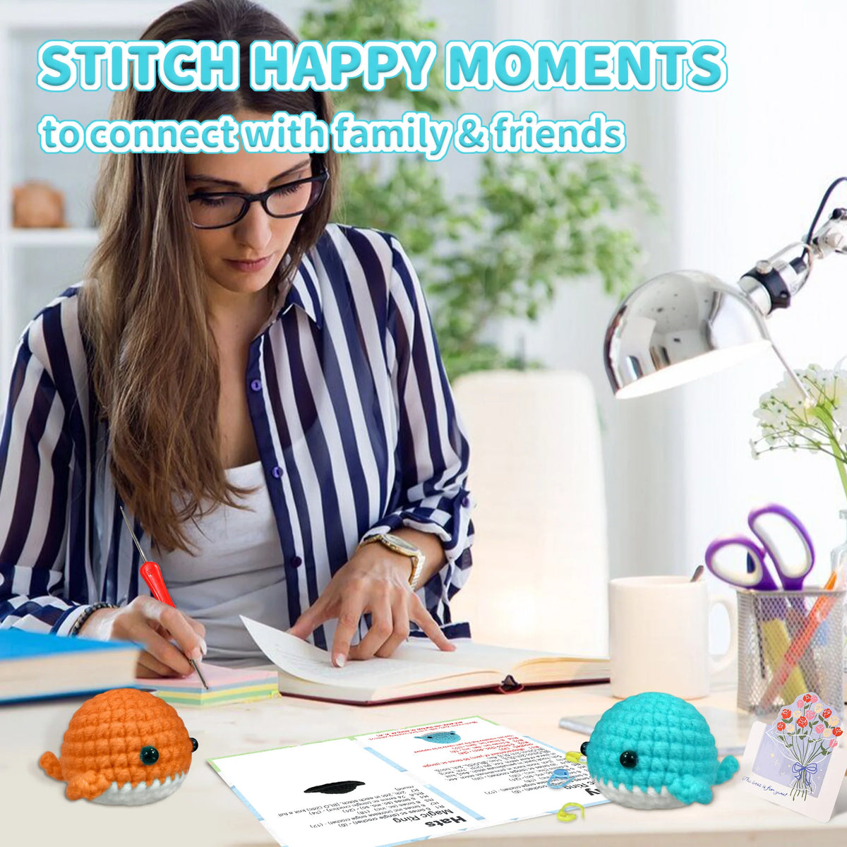 A woman is writing in a notebook surrounded by crochet items including an orange sea creature and a blue sea creature.