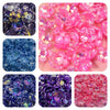 A collection of iridescent acrylic beads in various shades of pink and purple flowers for jewelry making