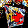 A clear resin dice set with a spinning dragon eye core featuring gold numbers on a black reflective surface.