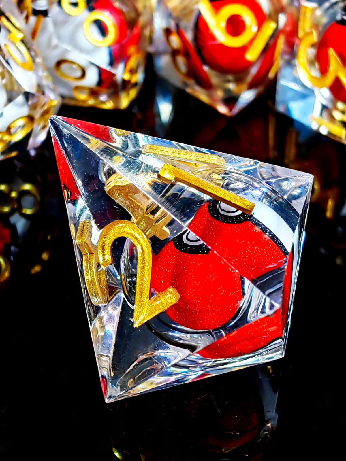 A clear resin dice set with a spinning dragon eye core featuring gold numbers on a black reflective surface.