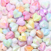 A pile of shiny, iridescent heart-shaped acrylic beads in various pastel colors for jewelry making
