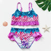 A girls two-piece rainbow swimsuit set featuring scales in shades of pink, purple, and blue.