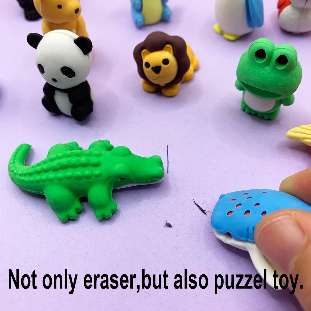 A collection of cute 3D puzzle animal erasers, including a panda, lion, frog, and crocodile, displayed on a purple surface.