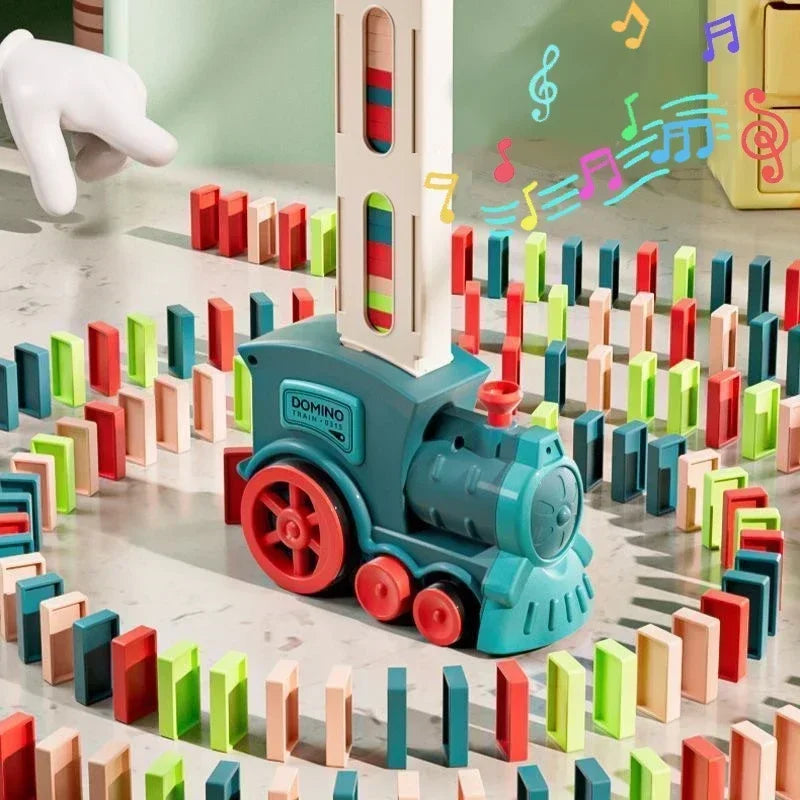 A toy domino train made of teal blocks is shown moving across a surface surrounded by colorful wooden blocks.