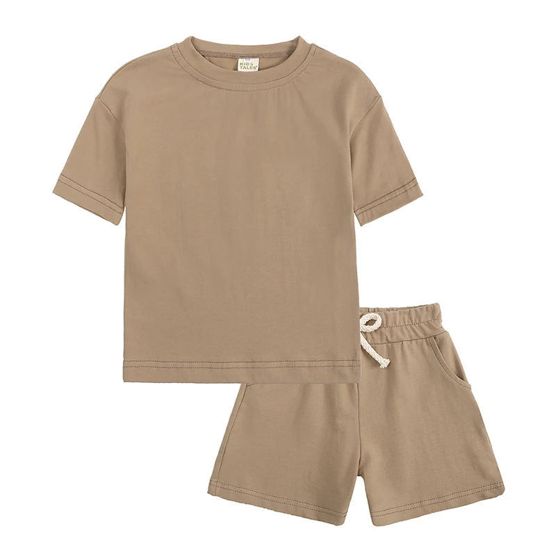 A beige kids summer tracksuit set featuring a short sleeve top and matching shorts.