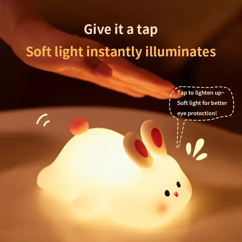 A soft white silicone rabbit night light illuminates a hand, demonstrating instant light activation for eye protection.