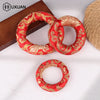 Handmade red singing bowl cushion with gold embroidery, shown in a ring shape.