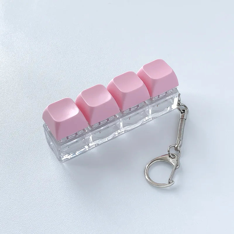 A clear acrylic fidget keychain featuring four pink clicky key buttons attached to a silver keyring.