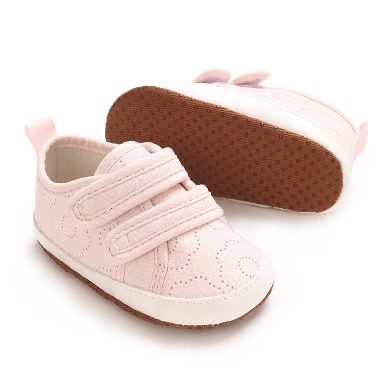 Pink baby first walkers with soft sole and white trim shown from the side.