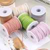 Rolls of pink, green, and gray velvet faux suede braided ribbon for crafting and gift wrapping