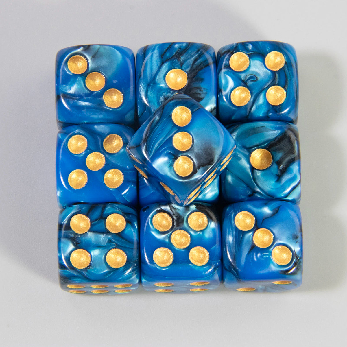 A set of ten blue acrylic dice with gold dots and marbled patterns.