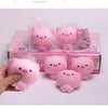 Pink squishy pig stress relief toys packaged in a box and being held by a hand