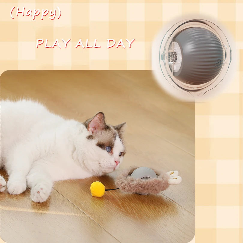 A white cat is playing with a yellow toy on the floor next to a motion-activated hide and seek cat toy.