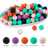 A variety of colorful silicone beads in various sizes and textures are displayed on a white plate.