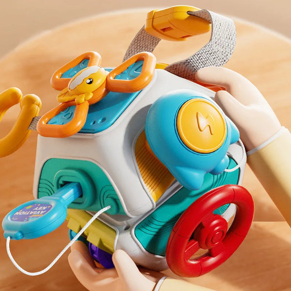 A child's hand holds a Montessori busy board for toddlers featuring bright colors and engaging components.