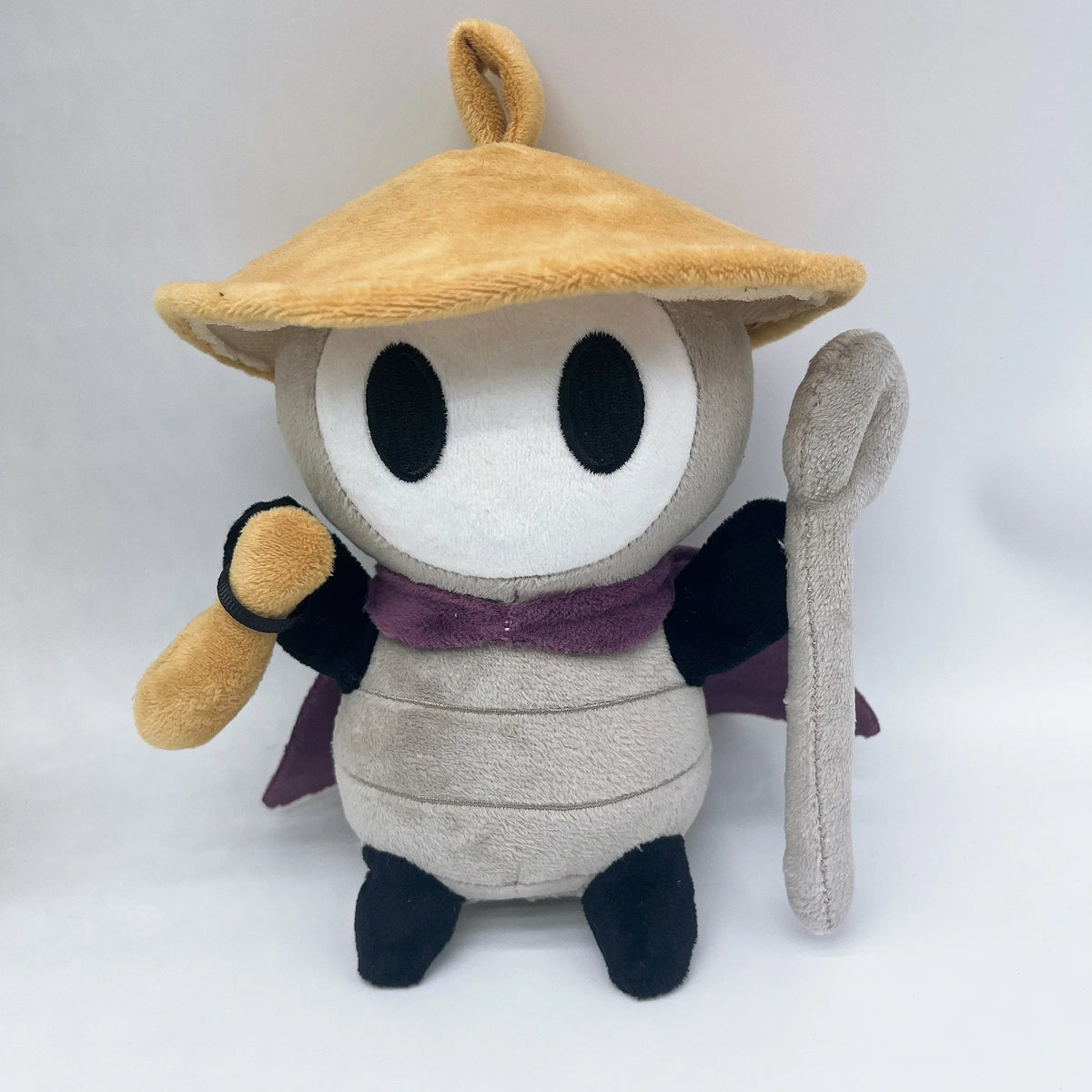 A plush doll resembling a character with a tan hat and dark clothing.