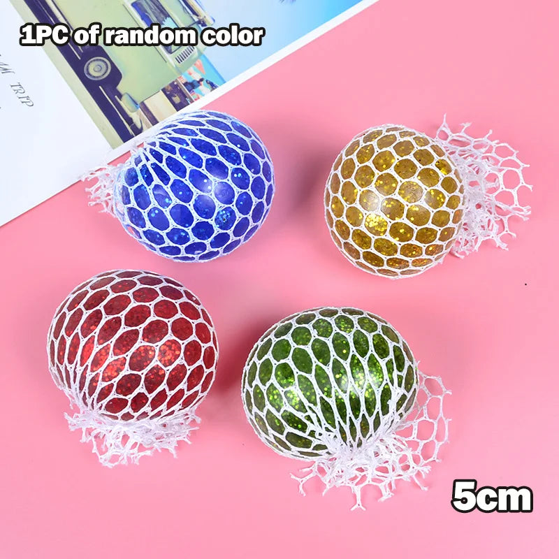Five colorful stress relief balls in blue, yellow, red, and green with mesh netting shown on a pink background.