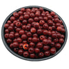 A pile of dark reddish-brown acrylic round beads for jewelry making in a black bowl.